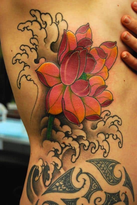 Hand poked shoulder tattoo including lotus flower