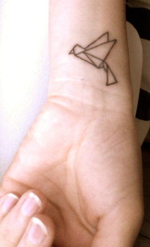 Inner arm tattoo of a origami bird, by Craigy Lee.