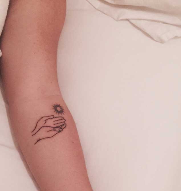 Cupped hand under sun tattoo