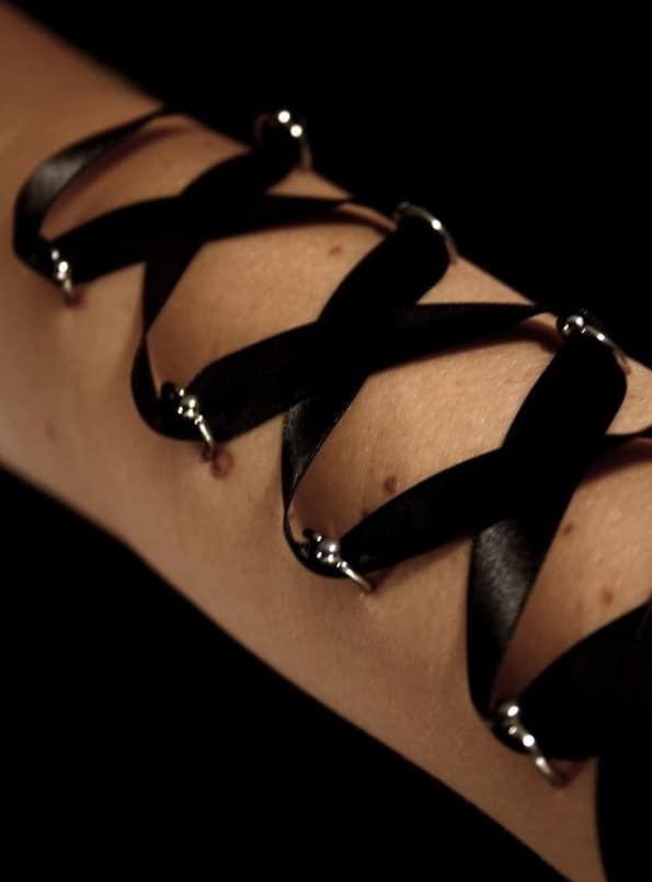 Black Ribbon Corset Piercings On Arm