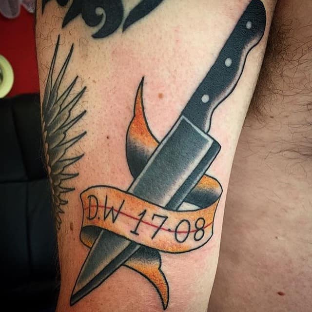 tattoos for men. knife with text tattoo on arm. 