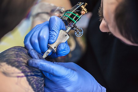 tattooist folosind arma tatuaj