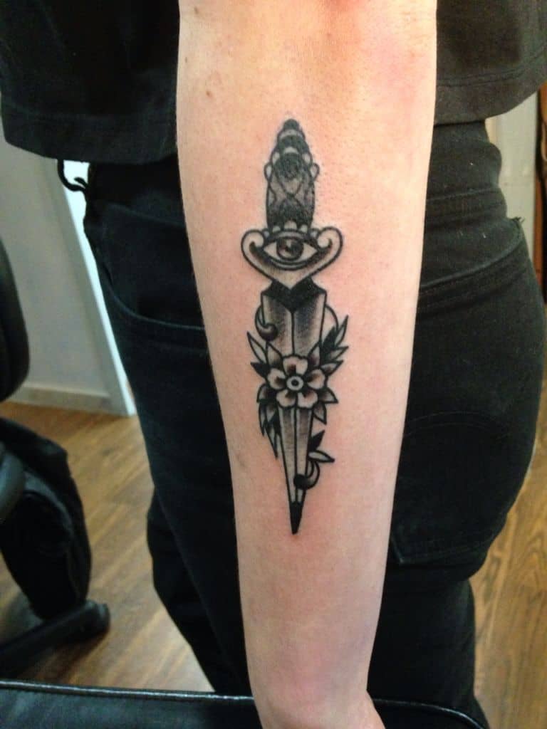 eye and dagger tattoo on arm