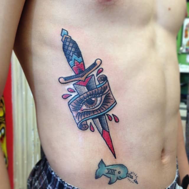 eye and dagger tattoo on rib