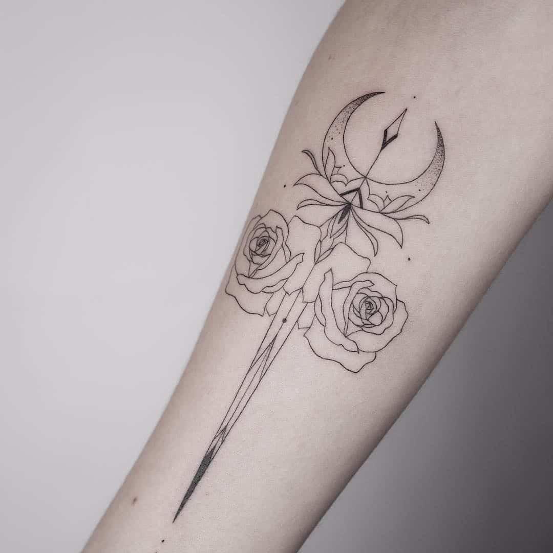 moon and dagger tattoo on arm