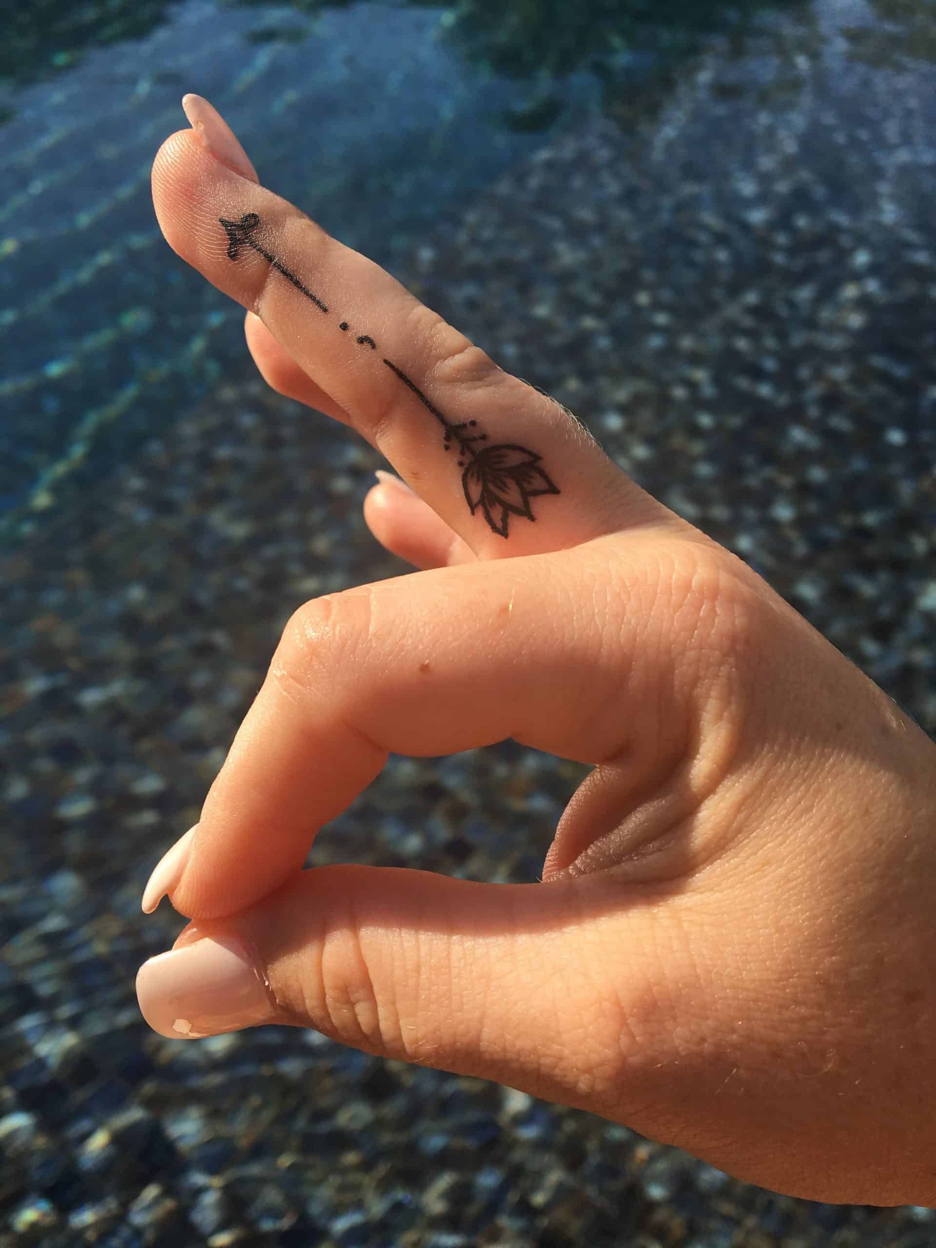 semicolon arrow tattoo on finger