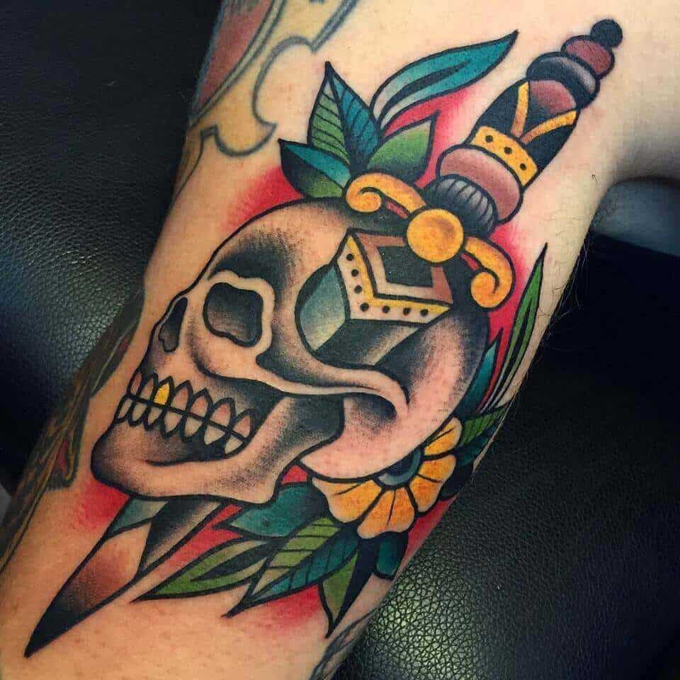 skull and dagger tattoo on arm