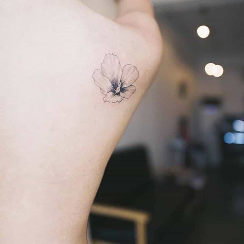small hibiscus tattoo on hand.