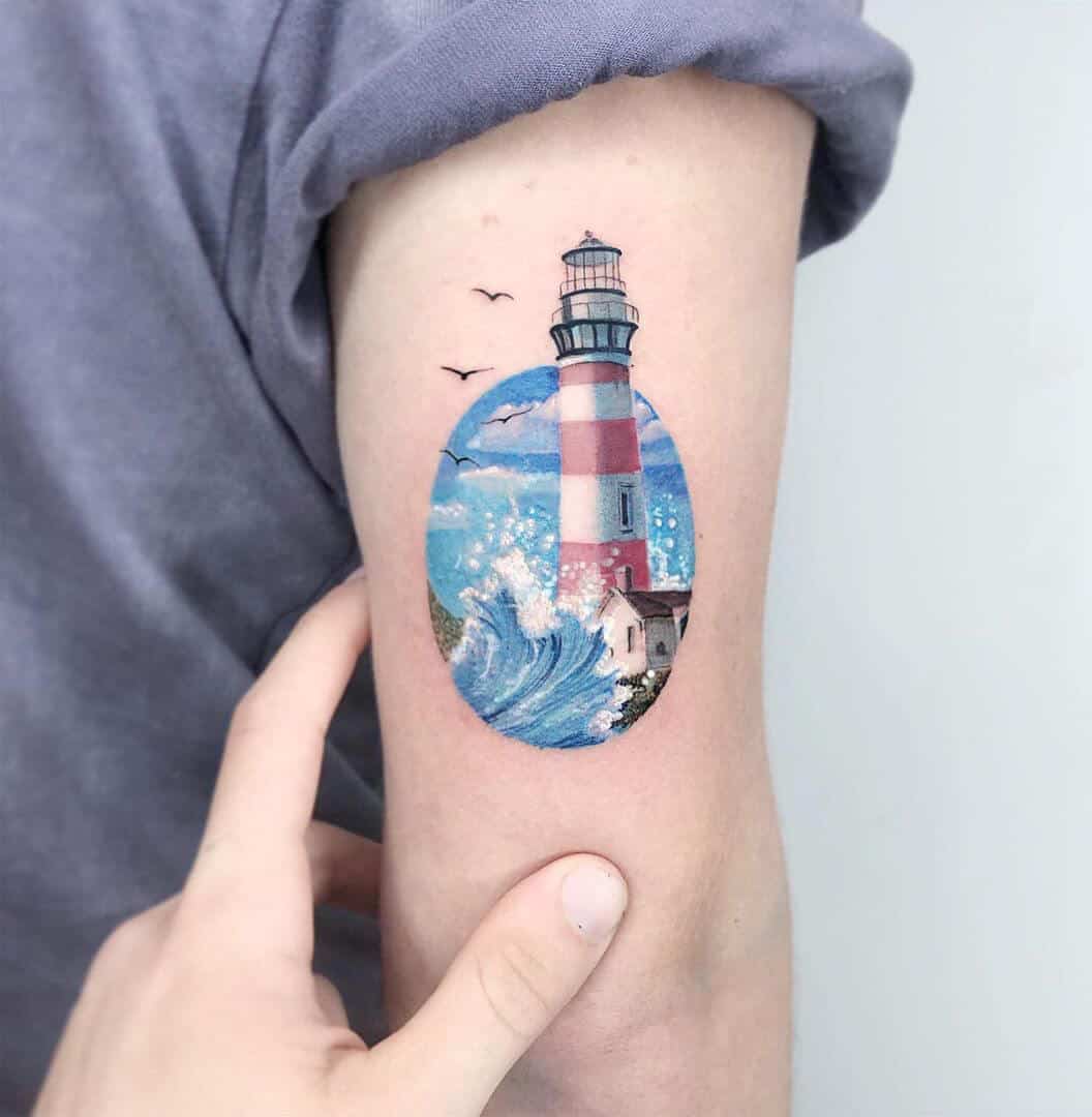 watercolor lighthouse tattoo on arm