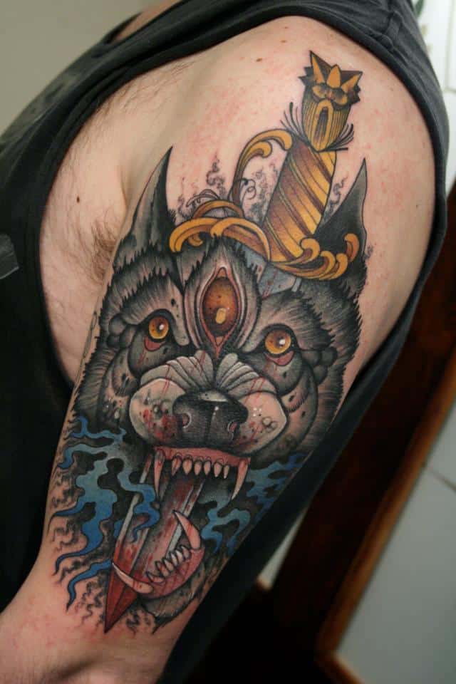 tatuaggio lupo e pugnale sul braccio
