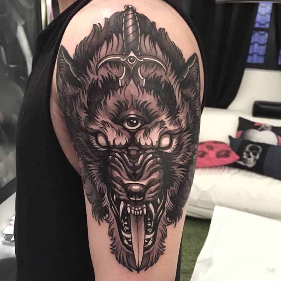 wolf and dagger tattoo on arm
