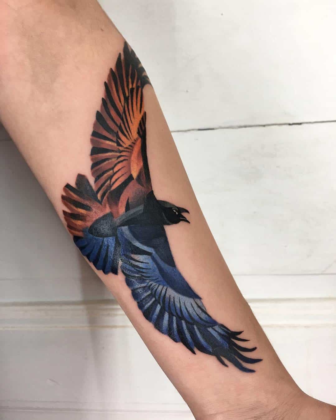 colored crow raven tattoo on arm