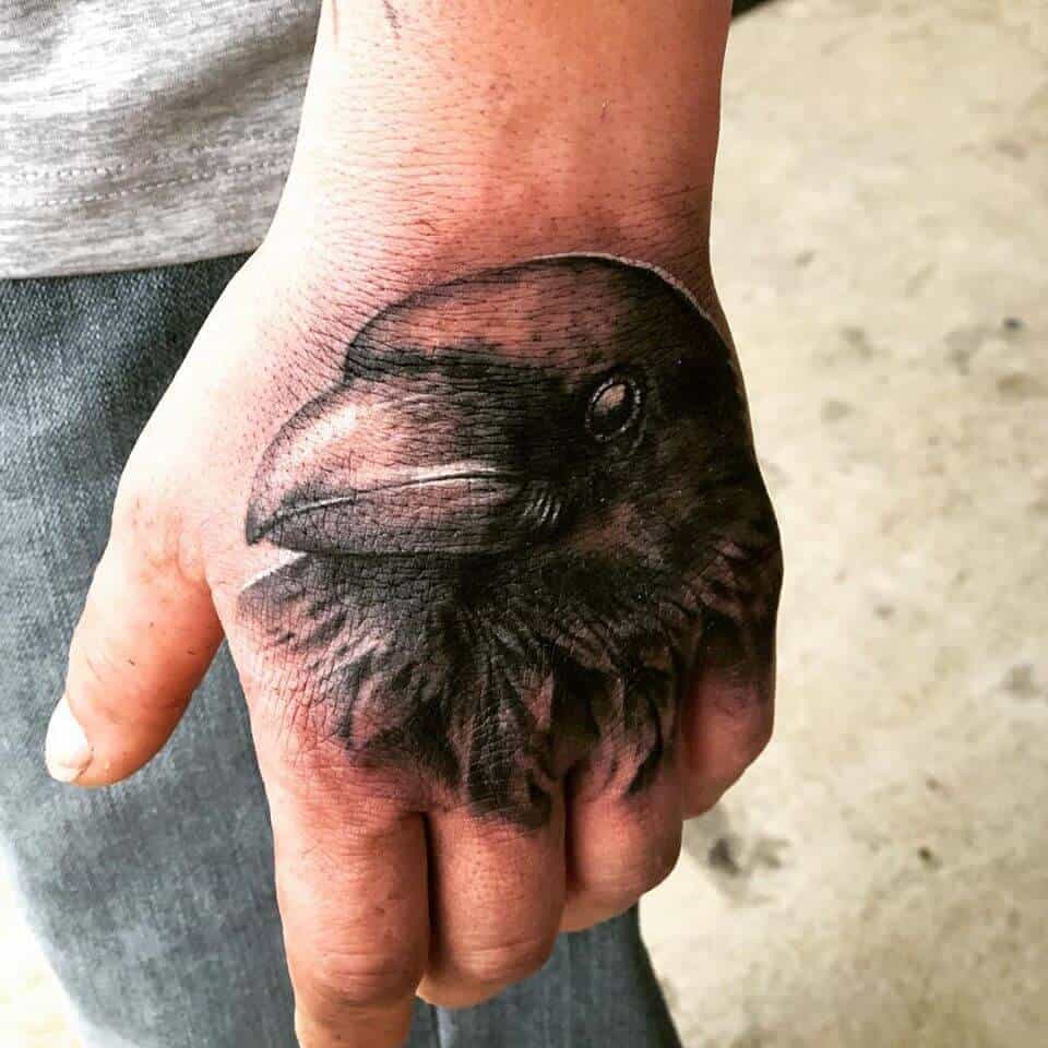 crow raven hand tattoo