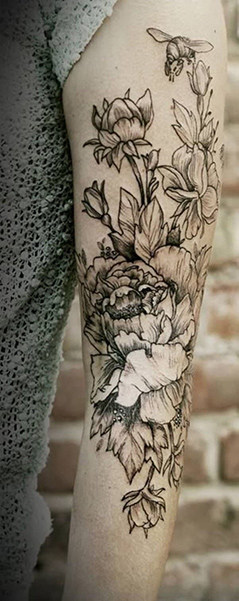 black flower tattoo on arm