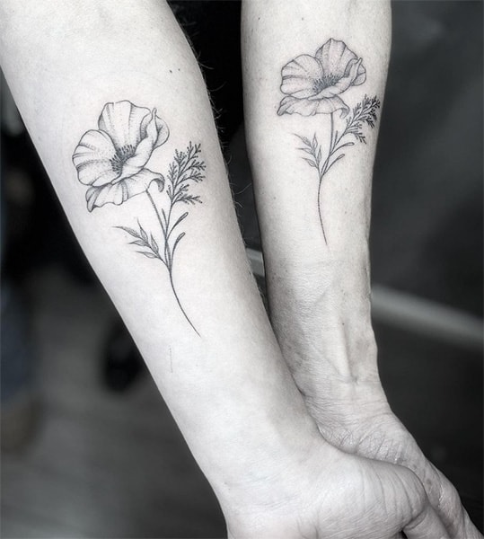 Matching mother and daughter tattoos of flowers